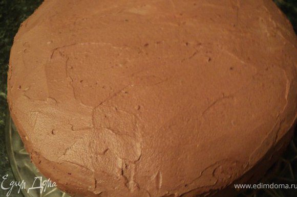 Обмазать шоколадным масляным кремом нижнюю часть торта их шоколадного бисквита. Поставить обе части торта в холодильник на 2-3 часа.
