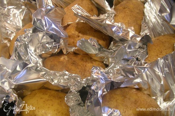 Картофель, моем, сушим. Заворачиваем каждую картофелину в фольгу и запекаем до мягкости в разогретой до 200 гр духовки около 1 ч (у меня около 1.15).