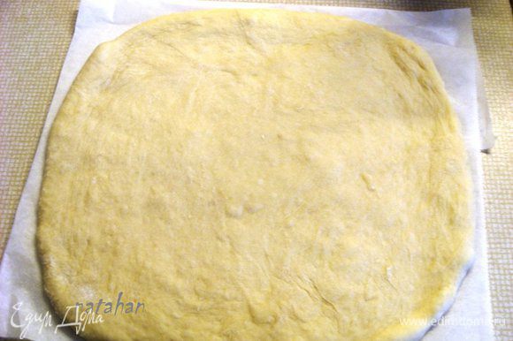 Мягкое тесто подмесить и на пекарской бумаге раскатать пласт толщиной 1 см.