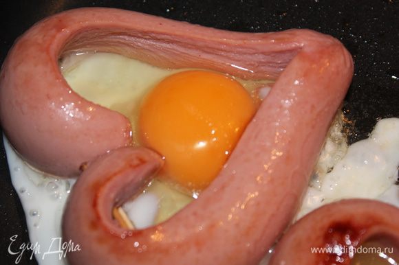 Переверните сердце и влейте в каждое по яйцу. Если немного белка вытечет наружу, не страшно, потом уберем (обрежем). Желток и часть белка должны оставаться жидкими (желательно, но не обязательно). Слегка посолить. Готовое сердце выложить лопаткой на тарелку.