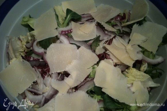 С помощью овощечистки нарезать Пармезан тонкими слайсами и добавить к салату...