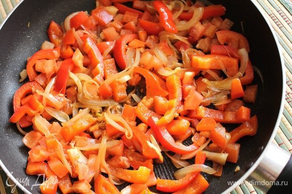 На раскалённом масле обжарить в течение 3-х минут порезанный крупной соломкой болгарский перец и лук, порезанный перьями вдоль. Выключить плиту, раздавить чеснок ребром ножа, порезать мелко, добавить к овощам, смешать. Туда же отправить порезанный кубиками помидор, подсолить овощную смесь.