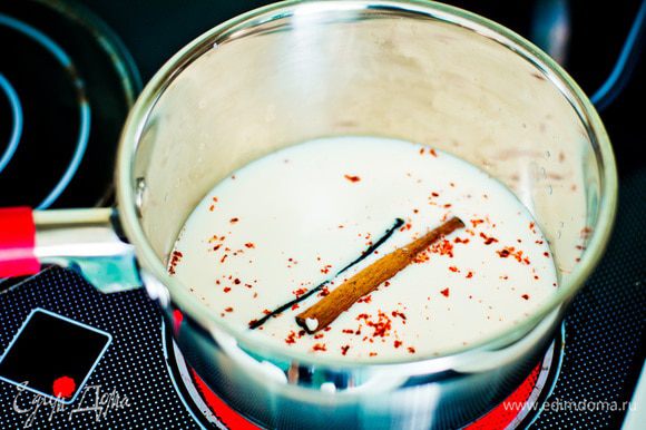 Стручок ванили разрежьте пополам. Прогрейте молоко с ванилью, палочкой корицы и порошком чили в течение одной минуты.