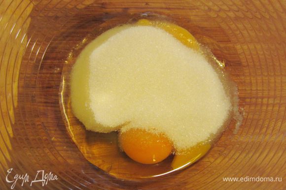Разбейте два яйца и положите в емкость вместе с сахаром и ванильным сахаром.