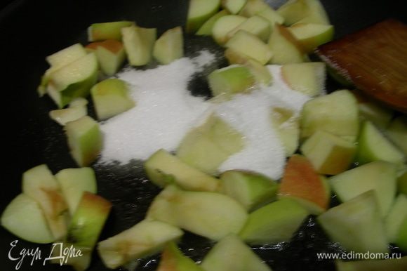 Разогреваем сливочное масло, добавляем 50 г сахара и яблоки, карамелизируем их минут 5-7.