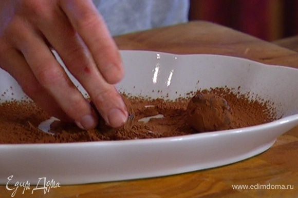 Набирать остывшую шоколадную массу ложкой, руками формировать небольшие шарики и обваливать в какао.