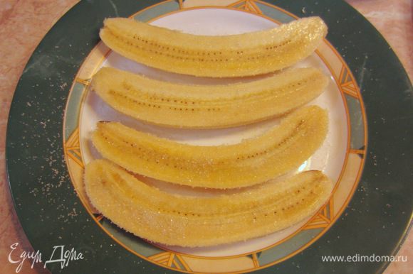 Выложите аккуратно бананы на тарелку и посыпьте с двух сторон сахаром. Подождите пару минут, чтобы сахар "прилип" к кусочкам банана.
