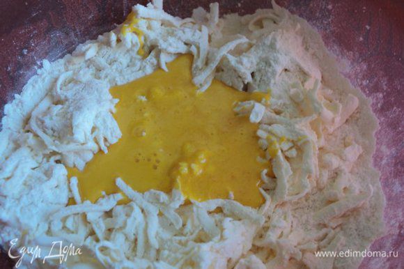 В муку натереть на терке охлажденное масло, добавить взбитые с сахаром желтки и быстро замесить тесто.