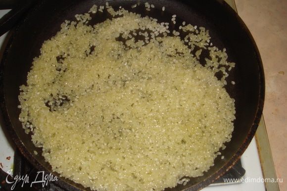 Обжариваем рис на сухой сковороде до впитывания масла.