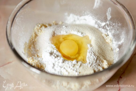 К полученной крошке добавить сахарную пудру, ванильный сахар, манную крупу, разрыхлитель, яйцо.