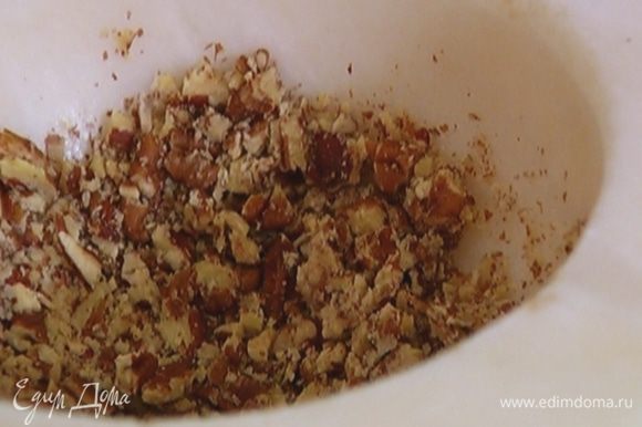 Большую часть орехов измельчить в ступке, чтобы остались небольшие кусочки, добавить в тесто и перемешать.