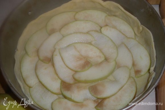 Теперь режем 1/3 часть яблок на очень тонкие слои и сразу укладываем на тесто. Я специально не стала заранее резать,чтобы не потемнели. Сверху посыпаем 1/3 части сахара.