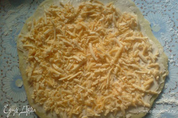 Тесто раскатать в пласт толщиной в несколько мм.Намазать сливочным или плавленным сыром. Сверху присыпать тертым сыром (немного сыра оставить, чтобы присыпать потом наши булочки).