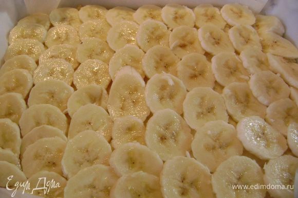 Вынуть форму с тестом из духовки, разложить по поверхности кружки бананов.