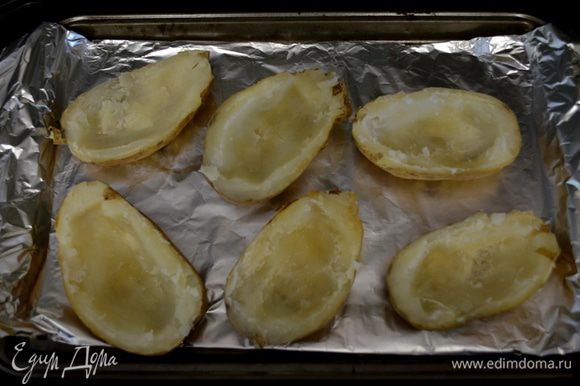Пока картофель в духовке, прожарьте бекон до хруста, выложите на бумажное полотенце, как остынет - поломайте его на кусочки. Когда картофель готов, ополовиньте его и у каждого картофеля снимите мякоть стол. ложкой вокруг, так чтоб мякоть была лишь у кожуры. Выложите картофель на противень.