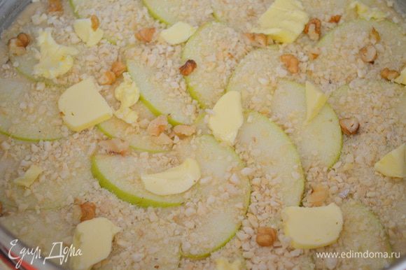 Выложить поверх яблок кусочки сливочного масла. Сверху посыпаем орешками, остатками сахара и корицы.