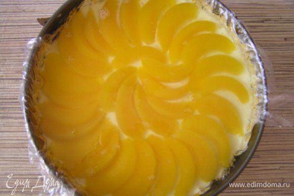 Персики нарезать дольками, аккуратно выложить на застывшее суфле, залить персиковым желе. Убрать в холодильник до полного застывания.