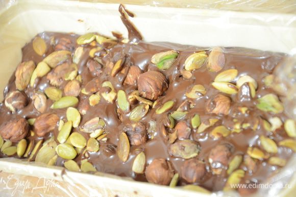 Вылить шоколад растопленный в форму, присыпать орехами и семечками тыквы. Поставить застывать в холодильник.