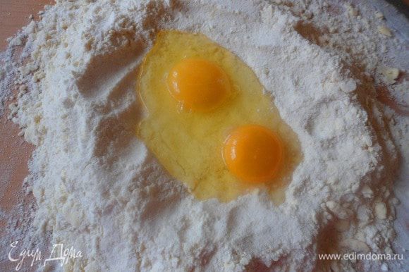 Сделать в муке с маслом углубление и разбить яйца (все ингредиенты должны быть холодными).