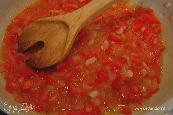 Добавить нарезанный перец, затем натертый помидор, всыпать сахар, перемешать и готовить соус на медленном огне.