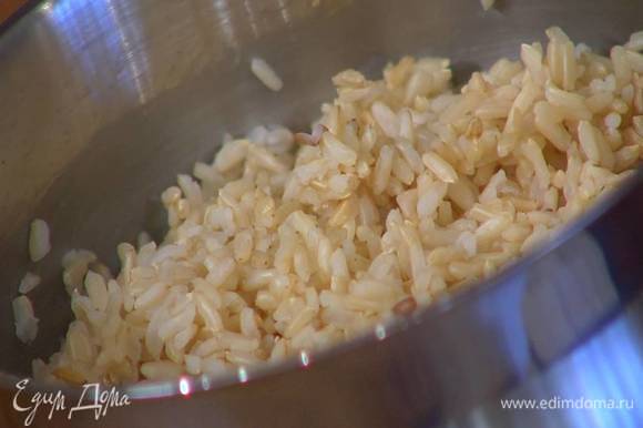 Рис всыпать в кастрюлю, залить бульоном, добавить имбирь, чеснок, цедру лимона и варить 20‒25 минут до готовности, в конце приготовления цедру удалить.