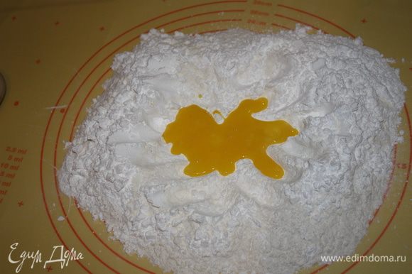 Сделайте углубление внутри, вылить желтки и добавить сливочное масло, порезанное кусочками,быстро замесить тесто.