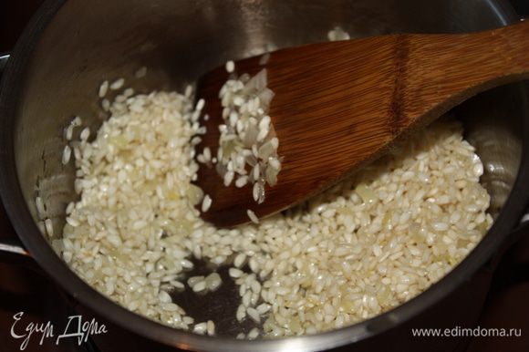Добавить рис и обжаривать на умеренном огне,пока рис не станет почти прозрачным. Посолить по вкусу. Увеличить температуру,влить вино и подождать пока оно выпарится.