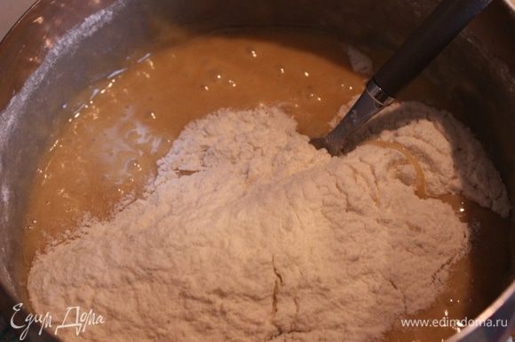 Снять кастрюлю с бани, небольшими порциями дождиком ввести муку и замесить тесто. Если получилось чересчур тугим и плотным, добавьте 1-2 ложки молока.