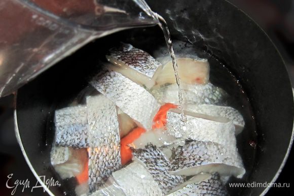 Поместите рыбу в кастрюлю с 2 литрами воды и варите 15 минут вместе с луком, морковью, лавровым листом и перцем. Не забывайте снимать накипь!