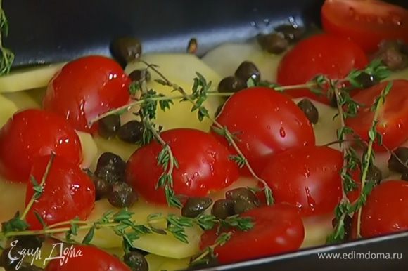На дно глубокой формы выложить кружки картофеля, затем половинки помидоров, посыпать каперсами, сбрызнуть 2 ст. ложками оливкового масла, разложить сверху 5–6 веточек тимьяна.