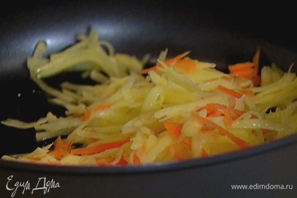 Разогреть в сковороде оливковое масло и обжарить картофель с морковью до золотистого цвета.
