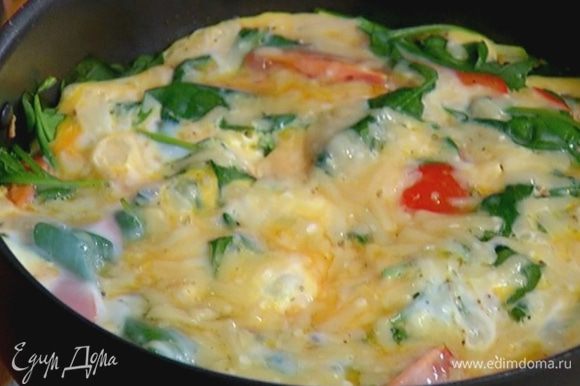 Влить яичную массу в сковороду, равномерно распределить, посыпать оставшимся сыром, накрыть крышкой и готовить еще несколько минут.