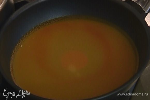 Сахар высыпать на сковороду, влить 200 мл воды, добавить апельсиновый экстракт и сварить сироп.