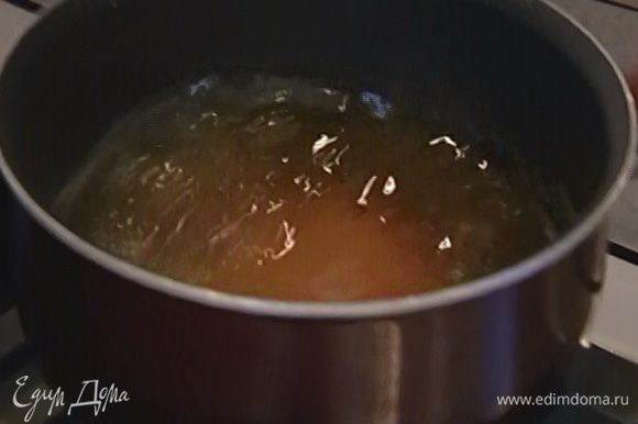 Приготовить карамель: оставшийся сахар всыпать в небольшую кастрюлю, залить 50 мл воды и на медленном огне сварить сироп, затем влить его в сковороду с кунжутом и, перемешивая, прогревать до золотистого цвета.