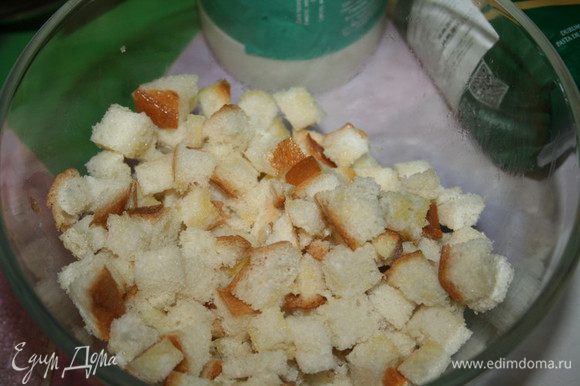 Ломтики хлеба нарезать кубиками, положить их в миску и полить растопленным сливочным маслом (50 г). Отставить в сторонку.