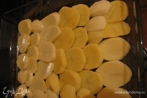 Картофель вымыть,очистить и нарезать не толстыми кружочками.В форму для запекания,смазанную маслом уложить внахлест половину ломтиков картофеля.