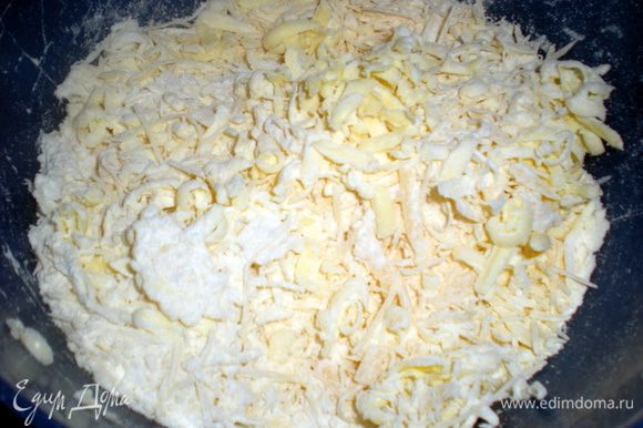 Сыр натереть на крупной терке. Масло замороженное так же натереть в муку, добавить яйцо и замесить тесто. Если получается суховатое, то можно добавить столовую ложку холодной воды.