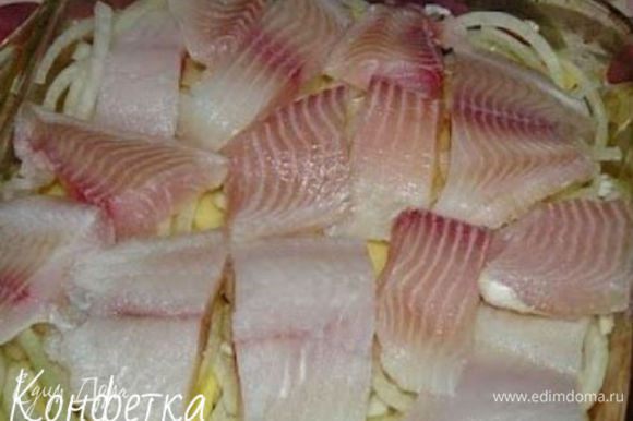 В сливки добавляем соль, перчик, можно еще какие-нибудь специи для рыбки. В форму сначала выкладываем слой картофеля, затем лучок, затем рыбка.
