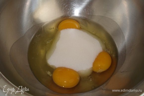 Духовку разогреть до 180°. В прямоугольную форму для кекса положить пергамент. Яйца с сахаром взбить до бела.