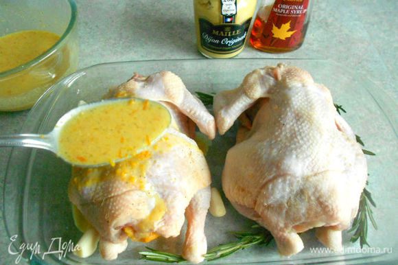 Цыплят выложить в огнеупорное блюдо, внутрь каждого поместить кожуру апельсина, вокруг чеснок и розмарин. Полить полученной глазурью.