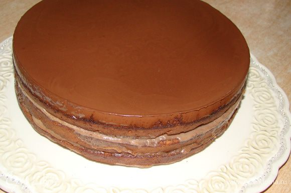 Закрепить тортовое кольцо (от разъемной формы, в которой вы выпекали торт) вокруг коржей, залить глазурью верх. Когда застынет - снять кольцо и обмазать бока
