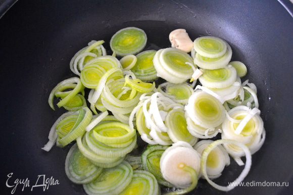В большой сковороде разогреем оливковое масло и добавим обжариваться лук вместе с раздавленным зубчиком чеснока