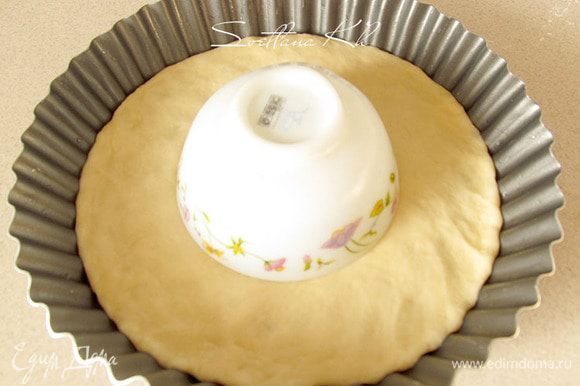 Выложить лепешку в смазанную форму, где будете выпекать пирог. Наметить центр круга и положить в круг перевернутое блюдце или пиалу. Там будет другая начинка.