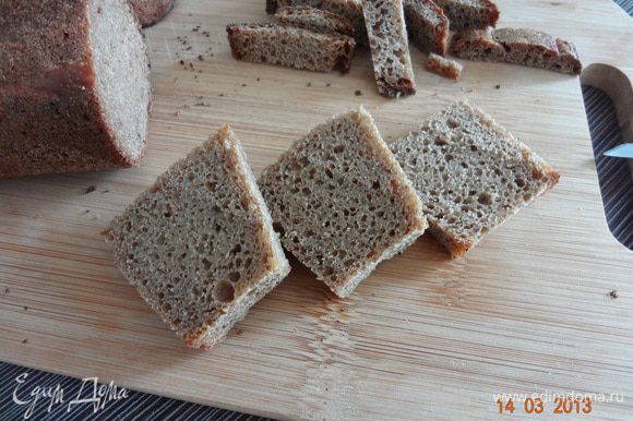 С кусочком ржаного хлеба срезать корочки, мякиш нарезать квадратиками со стороной 2-3 см. (я взяла тонкий ржаной багет, поэтому нарезать не пришлось).