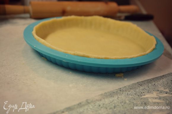 Достаем тесто из холодильника, раскатываем (на пергаментной бумаге, чтоб не прилипло к поверхности), чтоб получилось больше вашей формочки на 5 см. Тесто "наматываем" на скалку и выкладываем в формочку, хорошенько утрамбовываем тесто, лишние края обрезаем. Важно: края оставлять выше на 2 см, потому что тесто во время выпекания немного осядет.