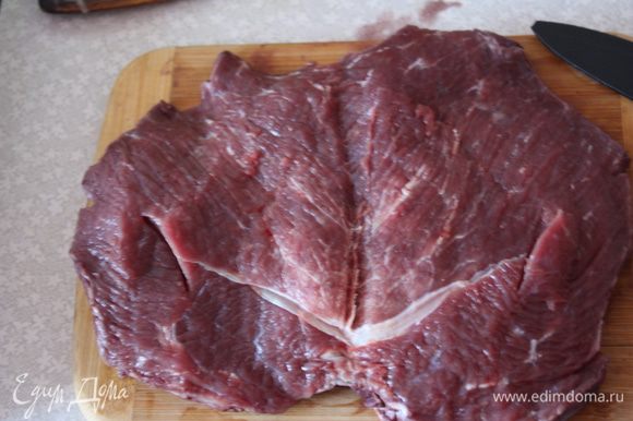 Мясо выньте из вина, надрежьте по центру и разверните как книжку. Необходимо отбить мясо, я делаю это через пищевую пленку, просто кладу в несколько раз сложенный кусок пленки на мясо и отбиваю молоточком.
