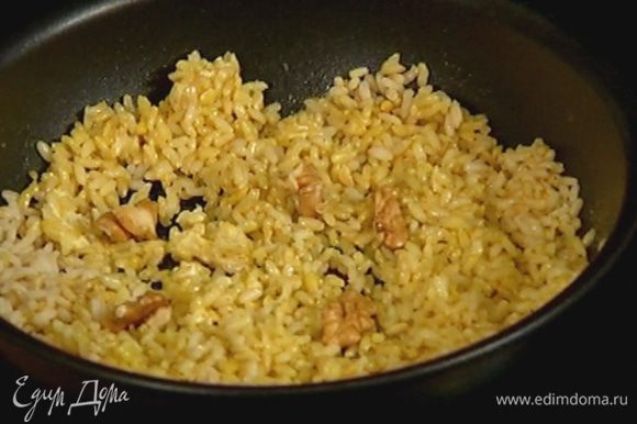 Орехи поломать руками, чтобы остались крупные кусочки, и добавить к рису.