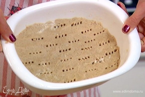 Небольшую керамическую форму для выпечки смазать оставшимся сливочным маслом, выложить тесто и разровнять (должен получиться пласт толщиной в 1–1 1/2 см), часто наколоть тесто вилкой и отправить в разогретую духовку на 20 минут.