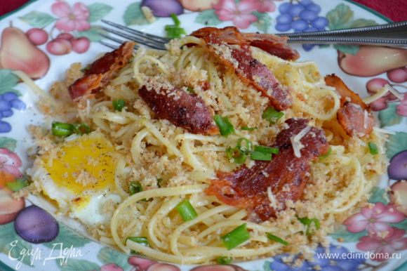 Разделить спагетти на 4 блюда.Также с беконом и яйцами,сверху посыпать хлебной крошкой из духовки,зеленым луком,пармезаном и посолить,поперчить по вкусу. Приятного аппетита.