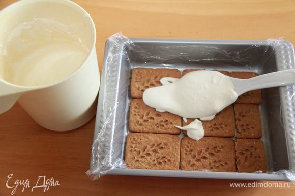 Половину молочно-сливочной смеси распределяем по печенью.